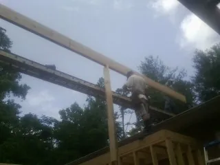 Carpenter setting a ridge beam over a new addition frame — Ice Dam Removal by Roofing Brothers in Royersford