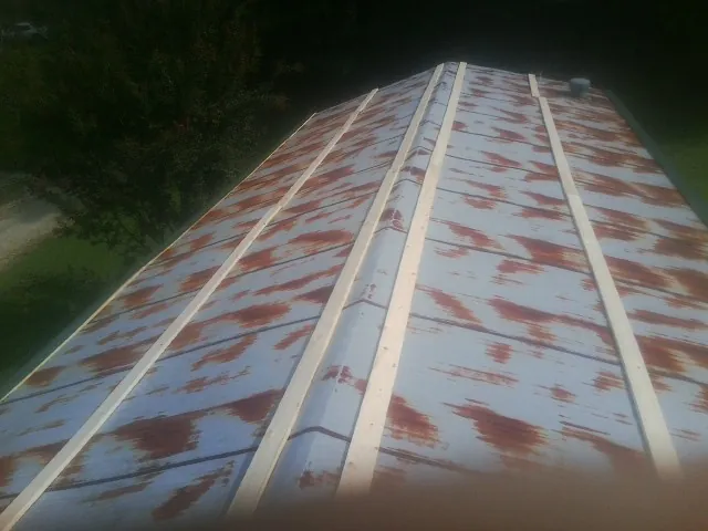 Rusted metal roof panels with new wood purlins before replacement — Storm Damage Roof Repair in Royersford by Roofing Brothers