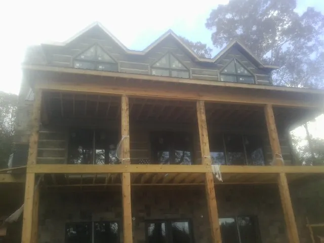 Dormers and porch framing on a large log home under construction — Roof Coating work by our crew in Royersford