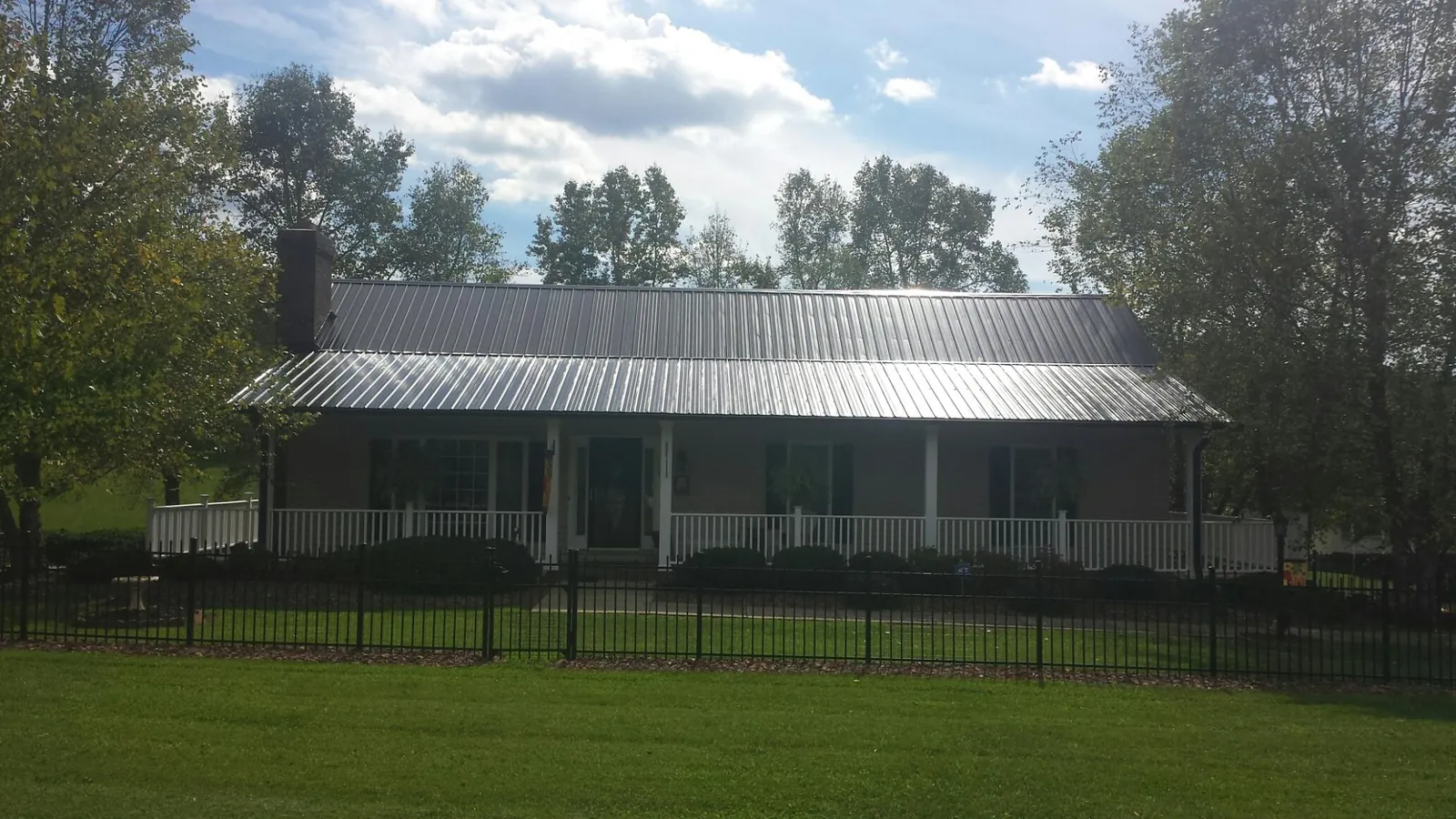 Gray metal roof on a brick ranch with a full width front porch — Gutter Guard Installation work by our crew in Royersford
